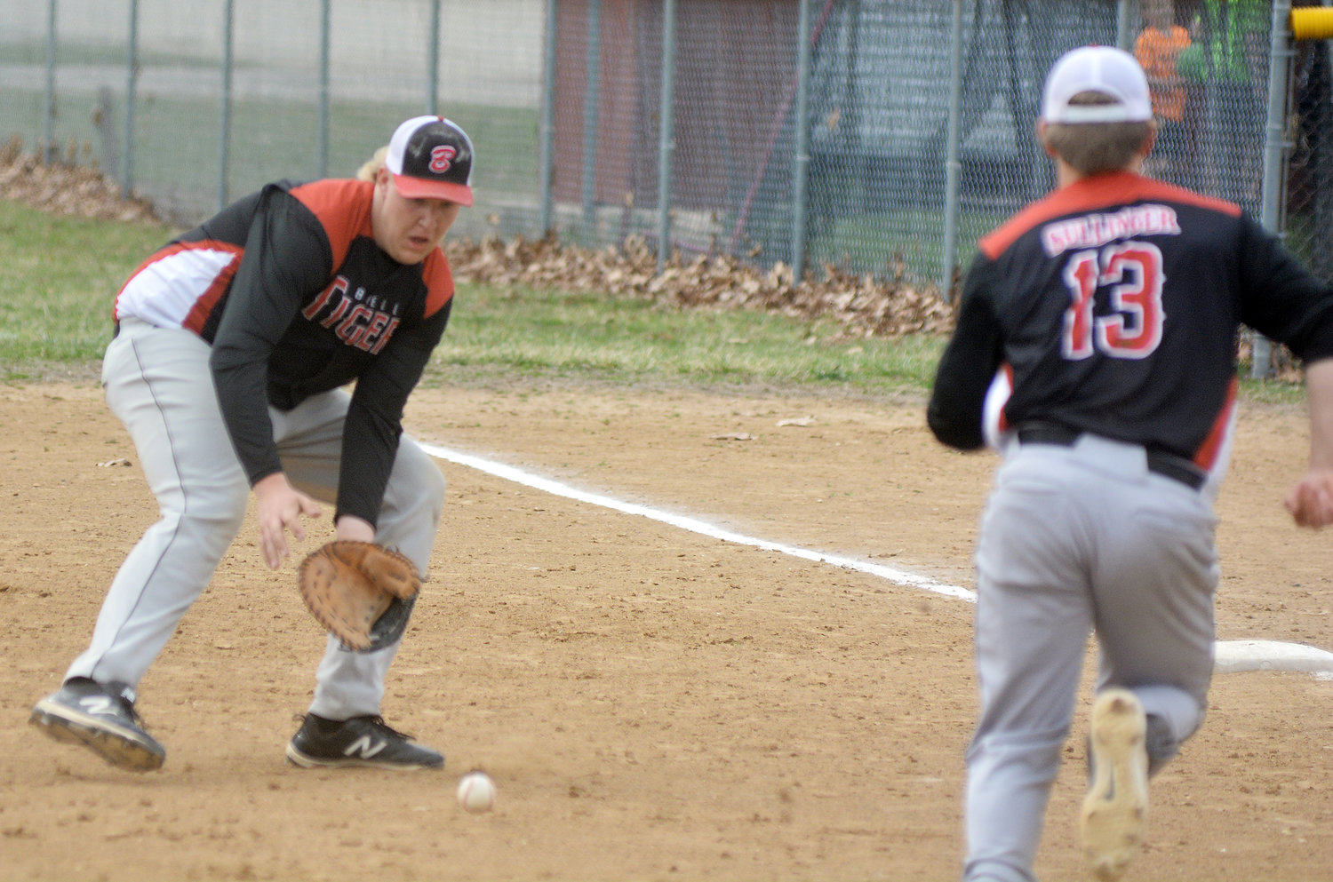 Zane Strunk (left) fields a ground ball while Isaiah Sullinger (above, right) charges towards first base to cover the bag while Strunk is fielding the baseball.